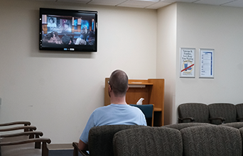 Man watching Digital Signage in Va Hospital Waiting Room