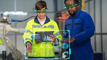 Two people looking at a holographic digital display. 