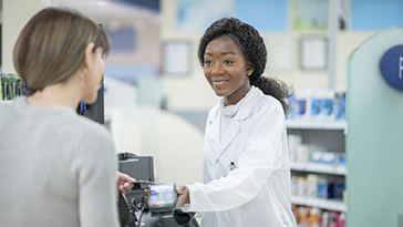 A pharmacy worker helping a customer 