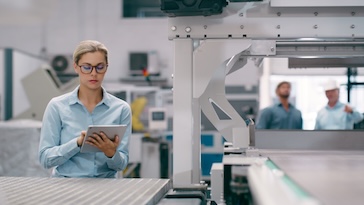 Woman looking at a tablet in a factory.