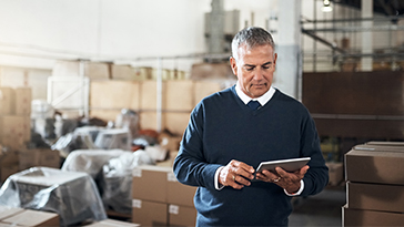 man in warehouse on tablet