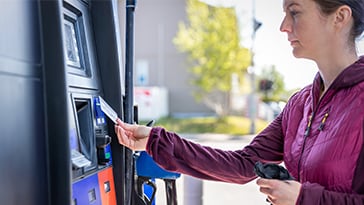 woman paying for gas at pump