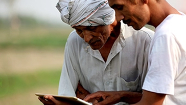 two men in India connected on tablet