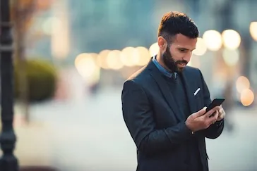 A man looking at his phone outside