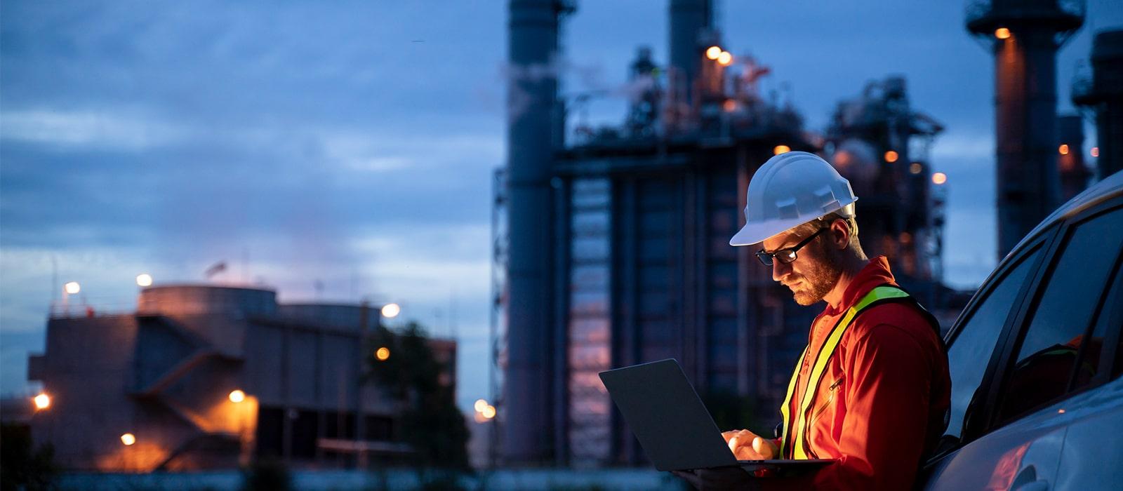 man outside energy plant on tablet