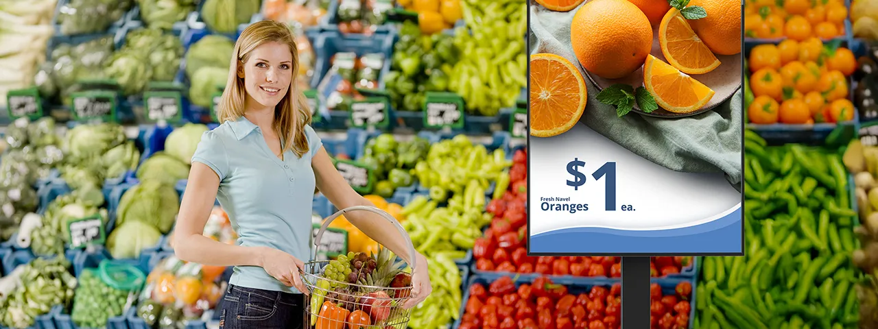 Woman grocery shopping next to signage