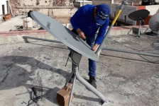 Hughes employee repairing a satellite dish