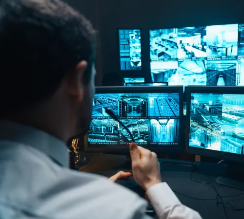 man looking at multiple monitors