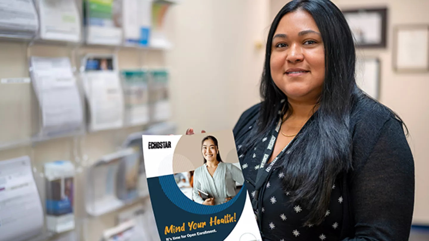 hughes employee holding a health brochure