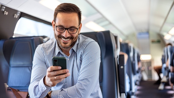 A man on his phone on a train