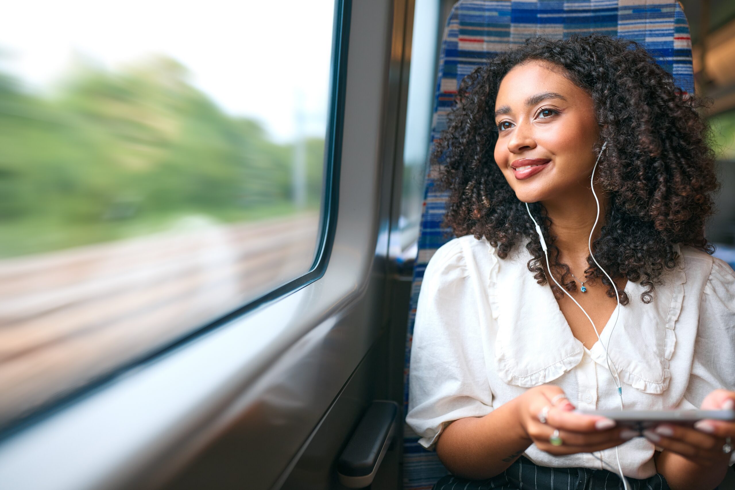 A woman on a train looking out the window