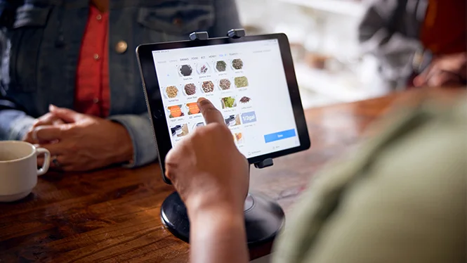 An employee using a point of sale app on a tablet.