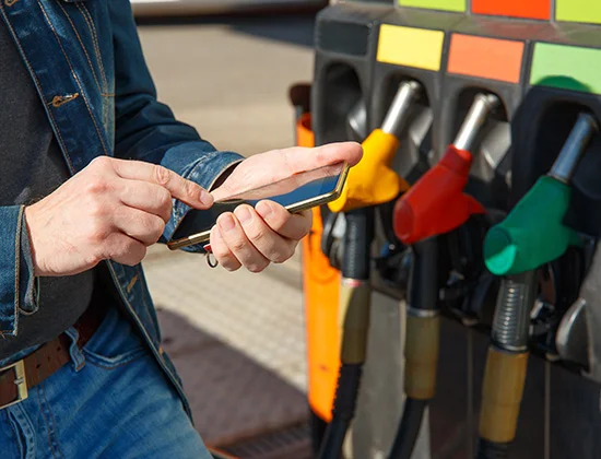 Refueling a car and paying using the application on a smartphone.; Shutterstock ID 1730192101; purchase_order: