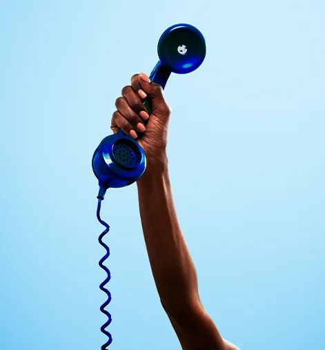 blue landline phone being held in the air