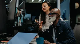 Two people collaborating and looking at a laptop together