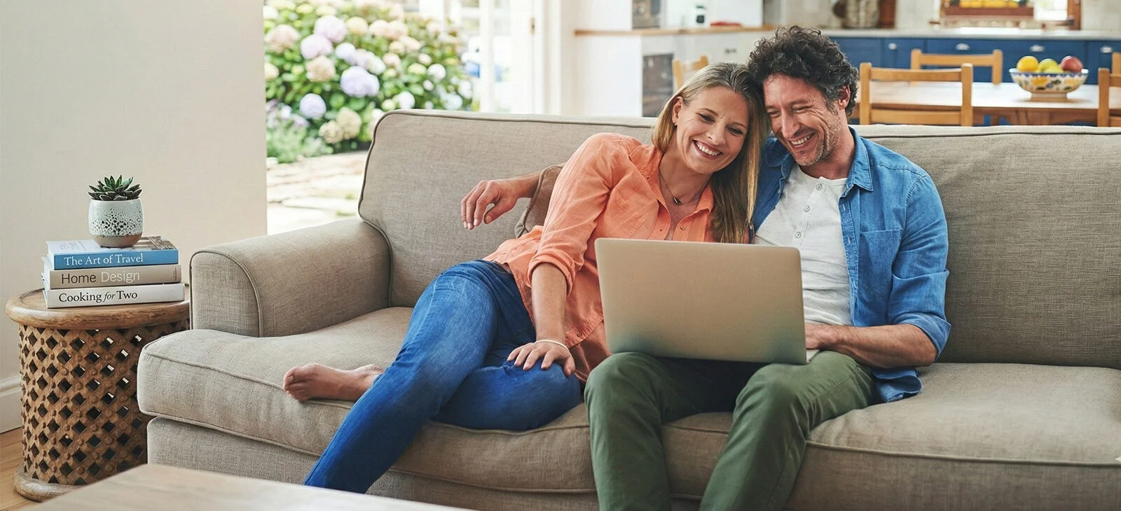 couple sitting on couch with laptop using Residential Satellite Internet from Hughesnet