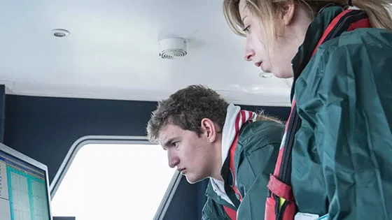 People on a ship using a computer